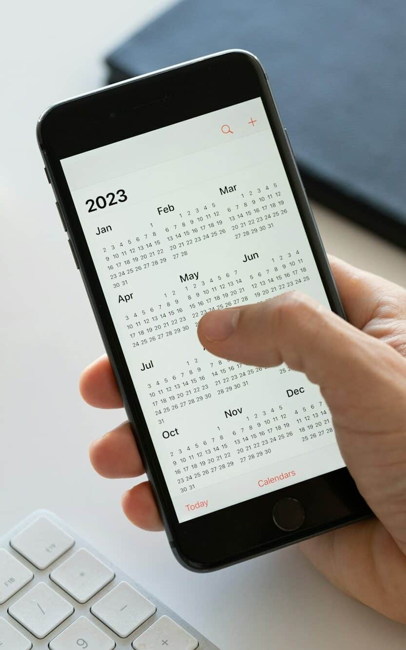 Hand holding a smartphone with a calendar program